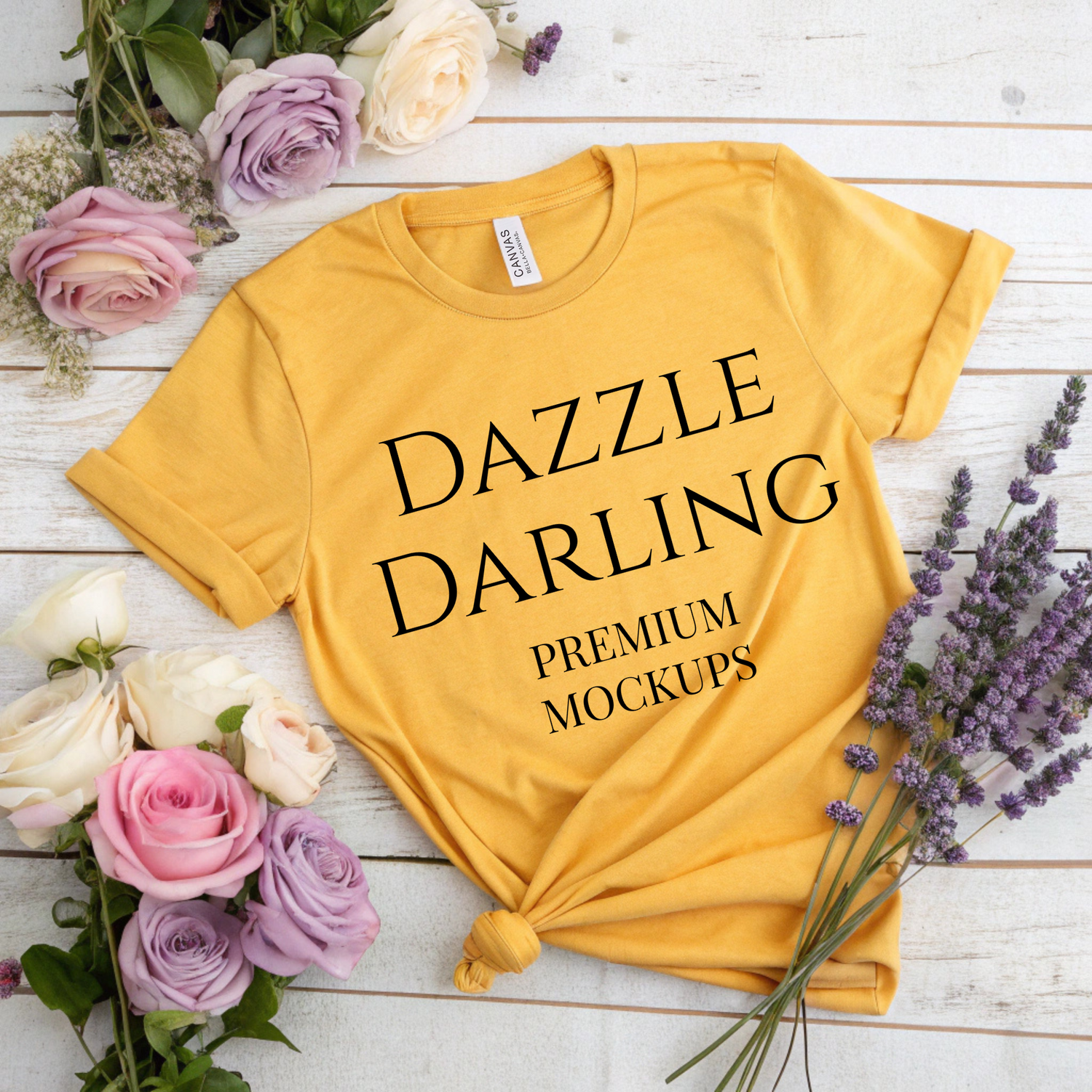 Yellow t-shirt with 'DAZZLE DARLING' text on a wooden surface with flowers.
