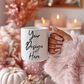 White mug with 'Your Design Here' text held by a hand against a festive background with candles and pumpkins.